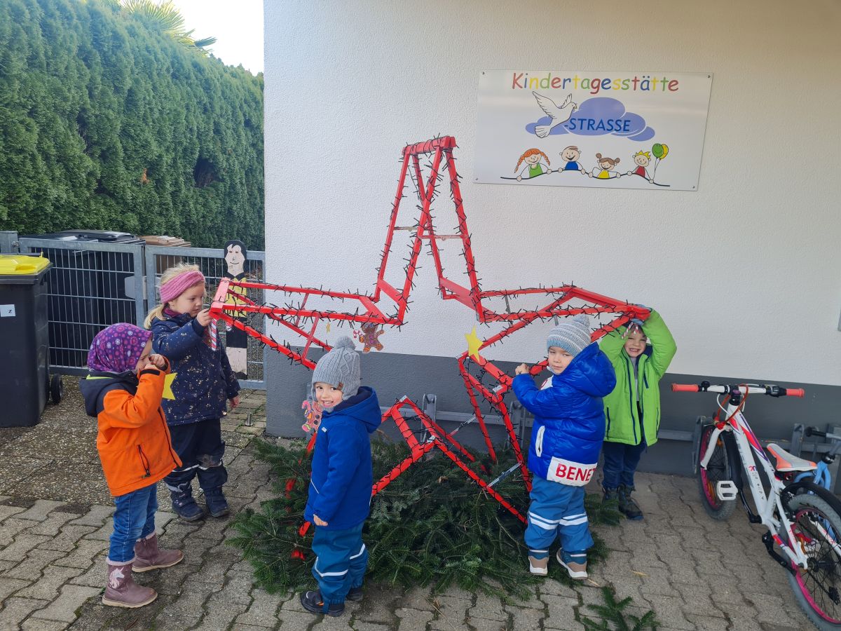 Kinder dekorieren den Holzstern.